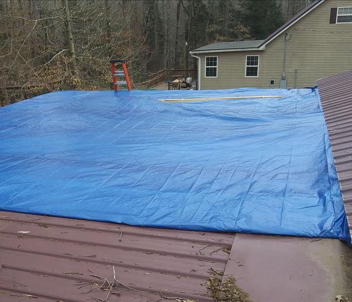 Installed tarp on roof to prevent further water damage.