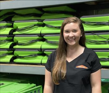 Girl standing in front of SERVPRO drying equipment