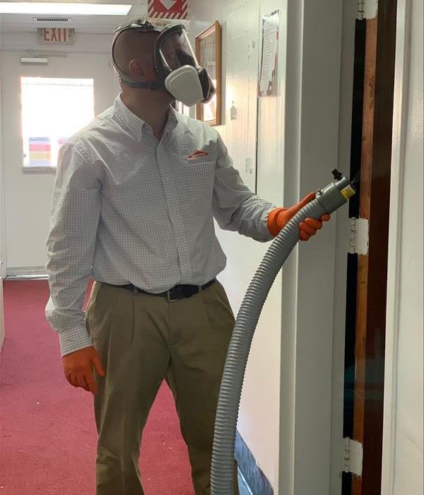 male employee in ppe fogging a facility